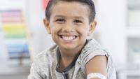A young boy smiling while in hospital gowns
