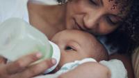 Baby being bottle fed by her mother