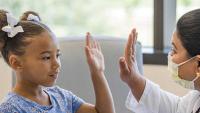 Little girl is giving a high five to her doctor