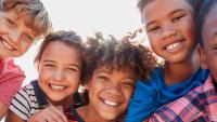 Group of smiling children outdoors.