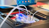 Close-up of the STAR device with a microfluidic chip and tubing mounted beneath a microscope for sperm detection and recovery.