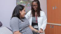 Gynecologist holds the hand of a patient in an exam room