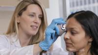 A dermatologist helps a patient with a skin condition