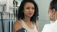 Doctor taking woman's blood pressure