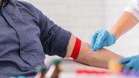 Close up of nurse disinfecting male arm before blood test.
