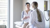 Patient speaks with doctor in exam room