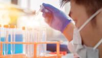 Person working in lab with test tubes