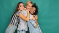 Three women smiling and embracing