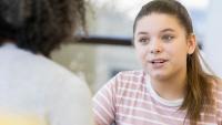 A teen girl speaking with a doctor
