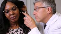 A doctor examines a patient's ear.