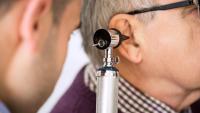 Doctor looking at patient's ear using an otoscope