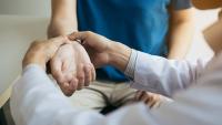 Woman has her wrist examined by a doctor.