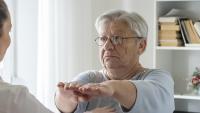 Elderly woman and doctor perform neurologocal exam.
