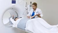 PET-CT Tech guides patient through PET test.