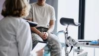 a patient sits on an exam table and listens to her gynecologist