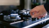 person turning on a gas stove