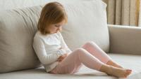 little girl on couch with a stomach ache