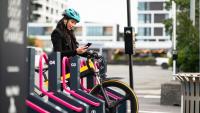woman unlocking an ebike from a docking station