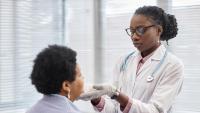 doctor examining patient thyroid