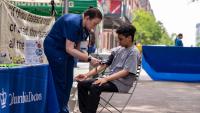 Columbia provider takes the blood pressure reading of young boy at the local Farmers Market.