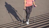 young woman walking with crutches upstairs