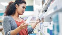 woman looking at medications in a pharmacy