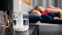 couple sleeping next to a humidifier by their bed