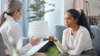woman talking to a woman therapist in light filled room