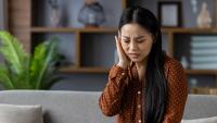 Woman experiencing ear pain.