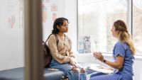 doctor talking to a patient on an exam table