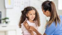 small kid getting a vaccine at the doctors office