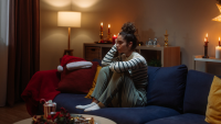 woman sitting alone in living room with holiday decorations