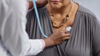 Doctor listens to a patient's chest with a stethoscope during a medical examination.