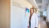 Doctor standing beside the Emilia Fazzalari Women’s Health Program sign.