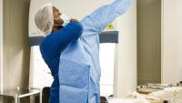 a young man puts on ppe as he prepares to manage infectious disease