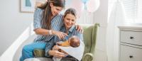 Two mothers at hospital holding their new born baby