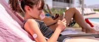 kid at the pool with a glucose monitor