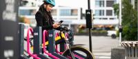 woman unlocking an ebike from a docking station