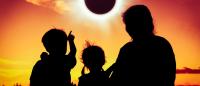 a view of the back of a family viewing the solar eclipse