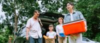 Asian family carrying cooler to picnic.