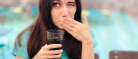 woman holding soda who looks like she might be trying to burp
