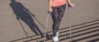 young woman walking with crutches upstairs