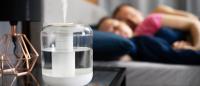 couple sleeping next to a humidifier by their bed