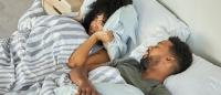 couple in bed together; woman annoyed by snoring