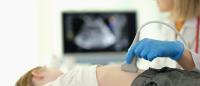 child receiving ultrasound of liver and pancreas from doctor