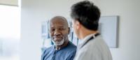 older black man in doctors office to doctor