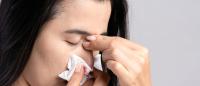 woman pinching her nose for nosebleed