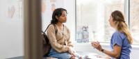 doctor talking to a patient on an exam table