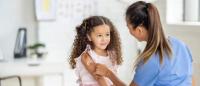 small kid getting a vaccine at the doctors office