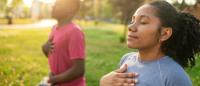 A young African-American woman sitting on a blue blanket in a park. She is wearing a blue t-shirt and has her eyes closed, as if she is deep in thought. Next to her, there is a young boy wearing a pink shirt and gray pants, who is sitting on the blanket.